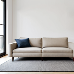 A contemporary studio apartment living area designed for optimal space efficiency. The scene features a sleek, professional-looking sofa in a neutral color, positioned in front of a bright window that lets in abundant natural light. An extendable coffee table sits centered on a minimalist rug. Along one wall, integrated, custom-built shelving units provide ample, discreet storage, displaying a few carefully curated, non-human decorative items and books. The overall aesthetic is clean, airy, and inviting, with a focus on smart design. perfect anatomy, correct proportions, natural pose, well-formed hands, proper finger count, natural body proportions, professional photography, high quality, safe for work, appropriate content, fully clothed, modest, family-friendly.